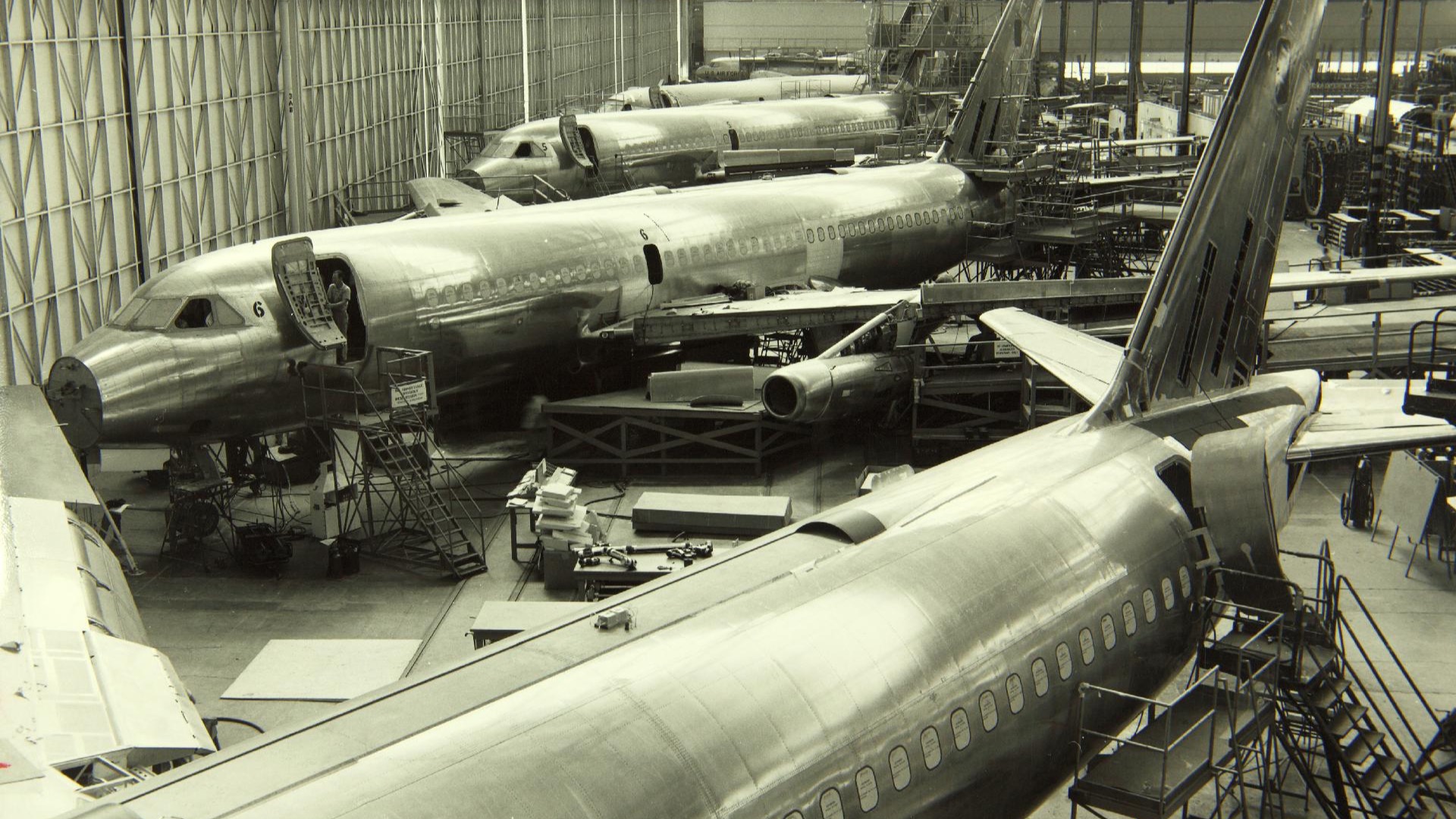 Convair 880 jetliners under assembly on a factory floor.