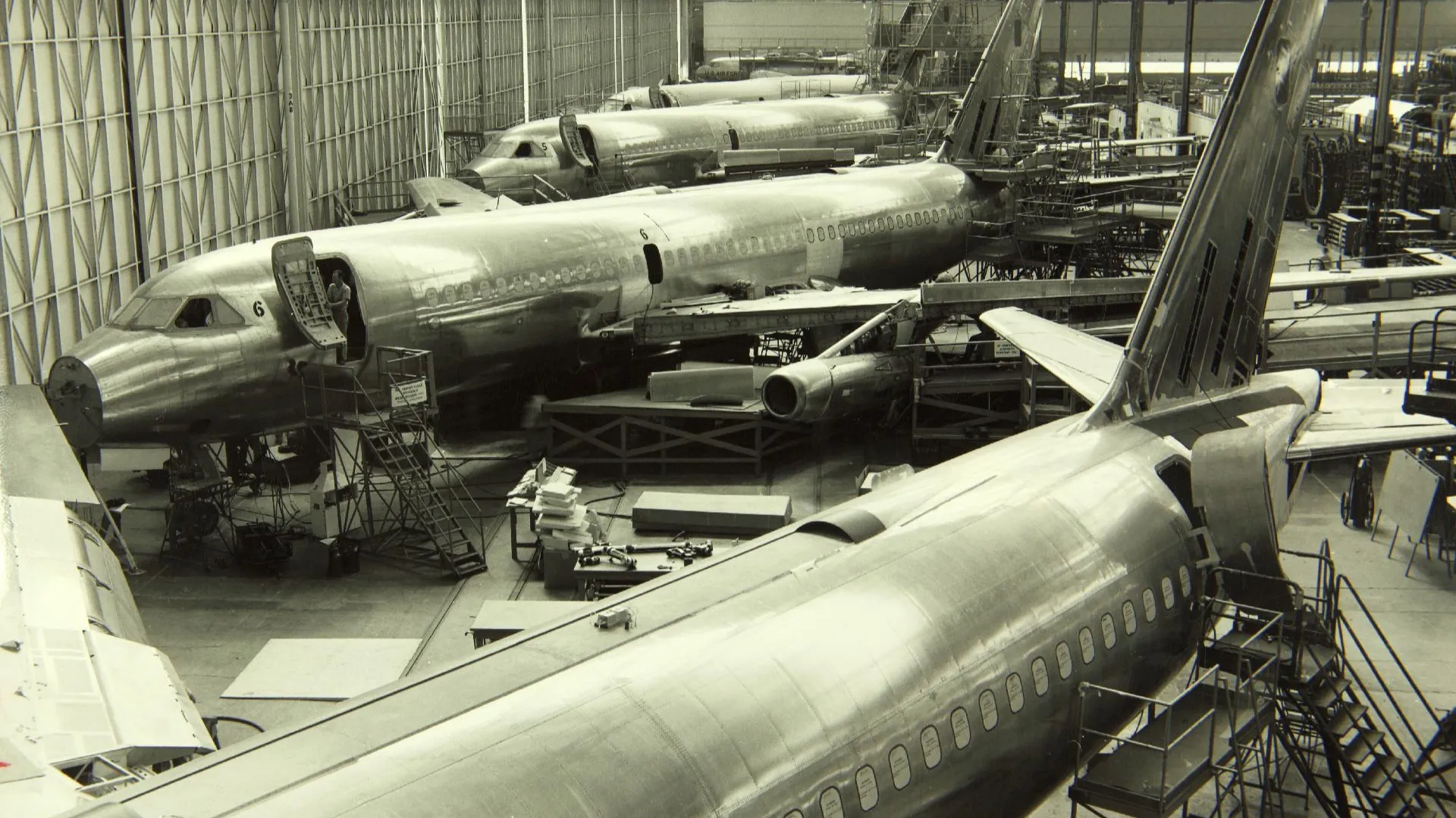 Convair 880 jetliners under assembly on a factory floor.